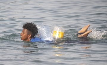 Un migrante intenta cruzar a España desde Marruecos, a 31 de julio de 2026, en Ceuta (España).